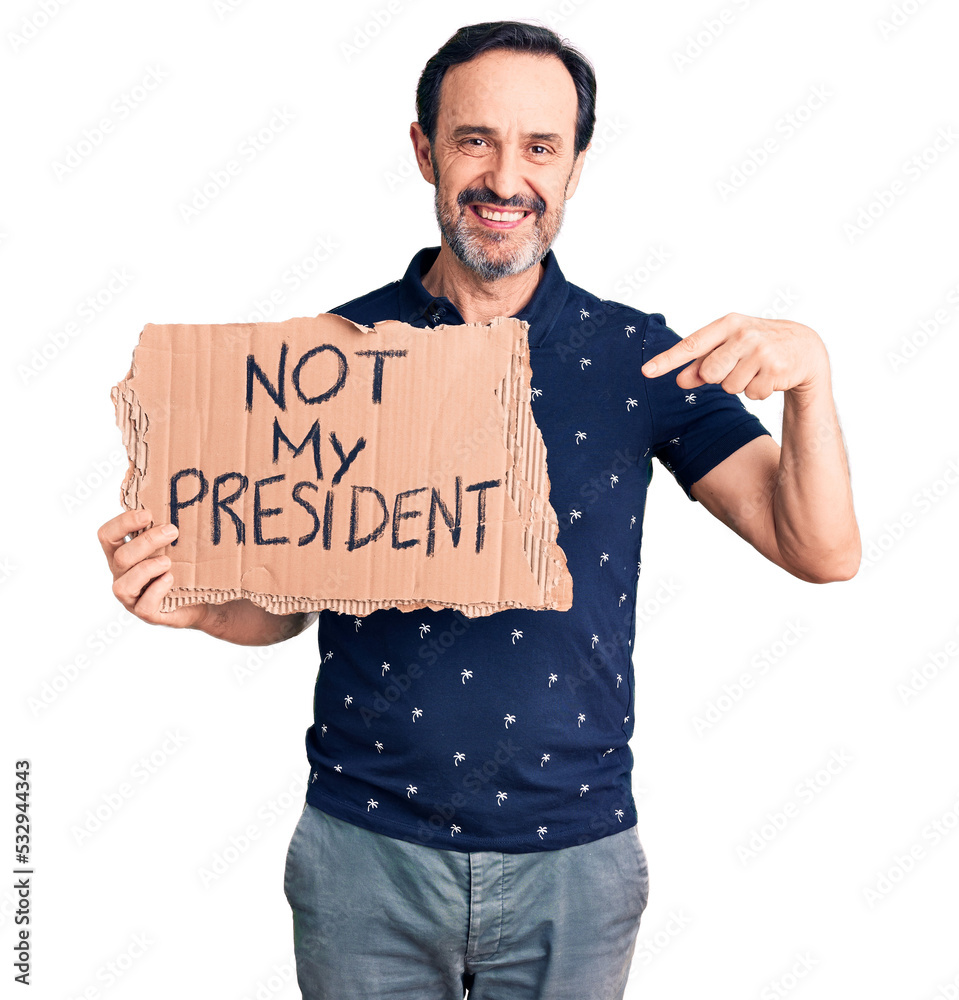 Middle age handsome man holding not my president carboard banner pointing finger to one self smiling happy and proud
