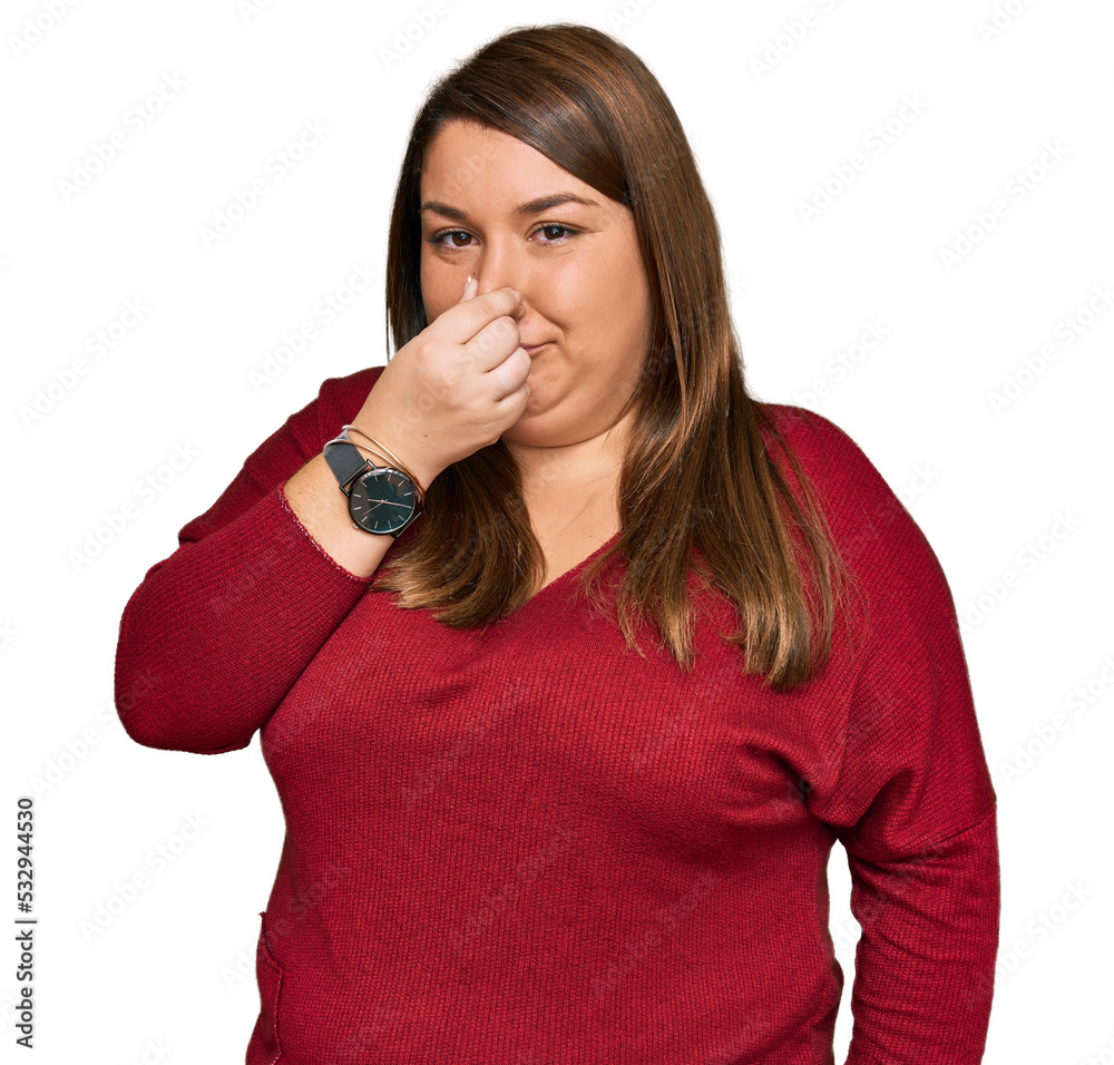 Beautiful plus size woman wearing casual clothes smelling something stinky and