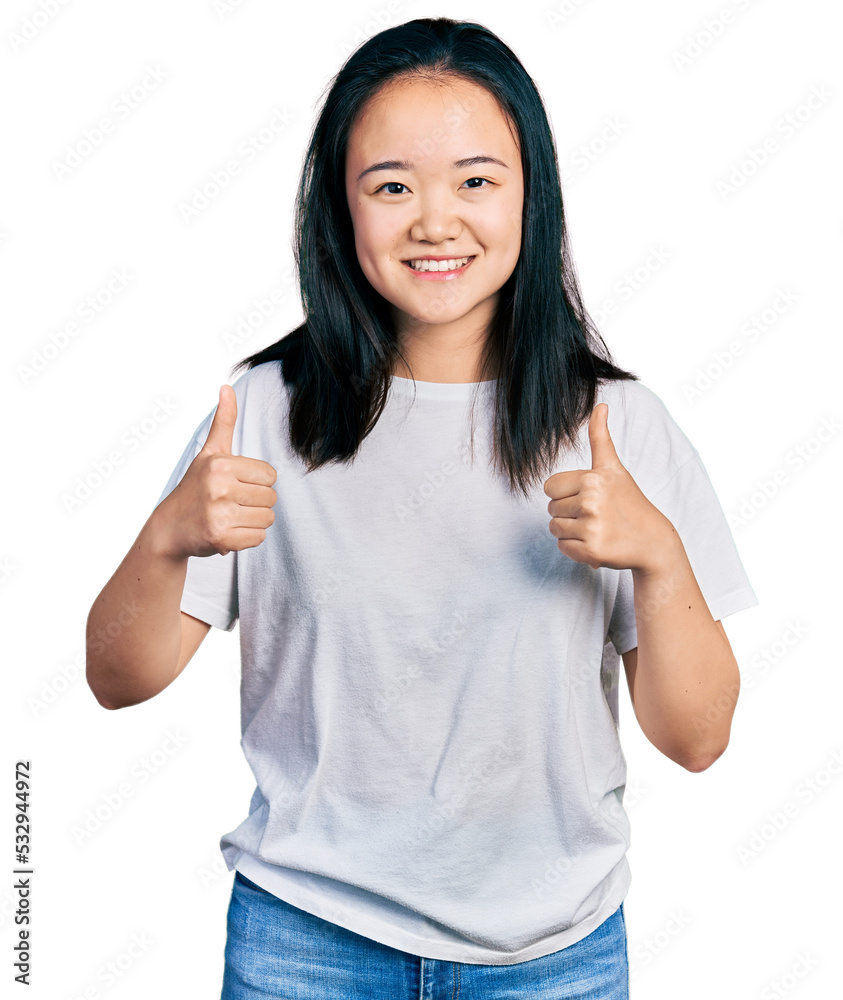 Young chinese woman wearing casual white t shirt success sign doing positive gesture with hand, thumbs up smiling and happy. cheerful expression and winner gesture. Young chinese woman wearing casual white t shirt success sign doing positive gesture with hand, thumbs up smiling and happy. cheerful expression and winner gesture.