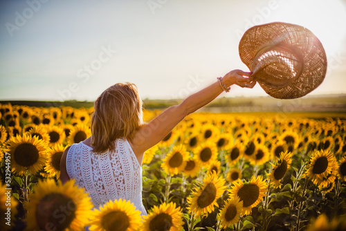 Fotografering beautiful woman saying goodbye in the field of sunflowers near el puerto de sant