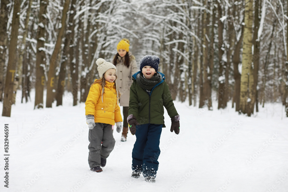 Happy family playing and laughing in winter outdoors in the snow. City park winter day.