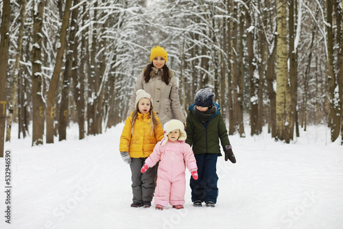 Happy family playing and laughing in winter outdoors in the snow. City park winter day. © alexkich