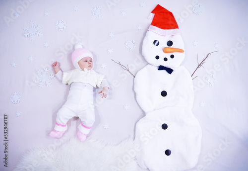 Newborn baby on a white background. Painting from white fabric. Snowman and baby. Christmas Holidays. © alexkich
