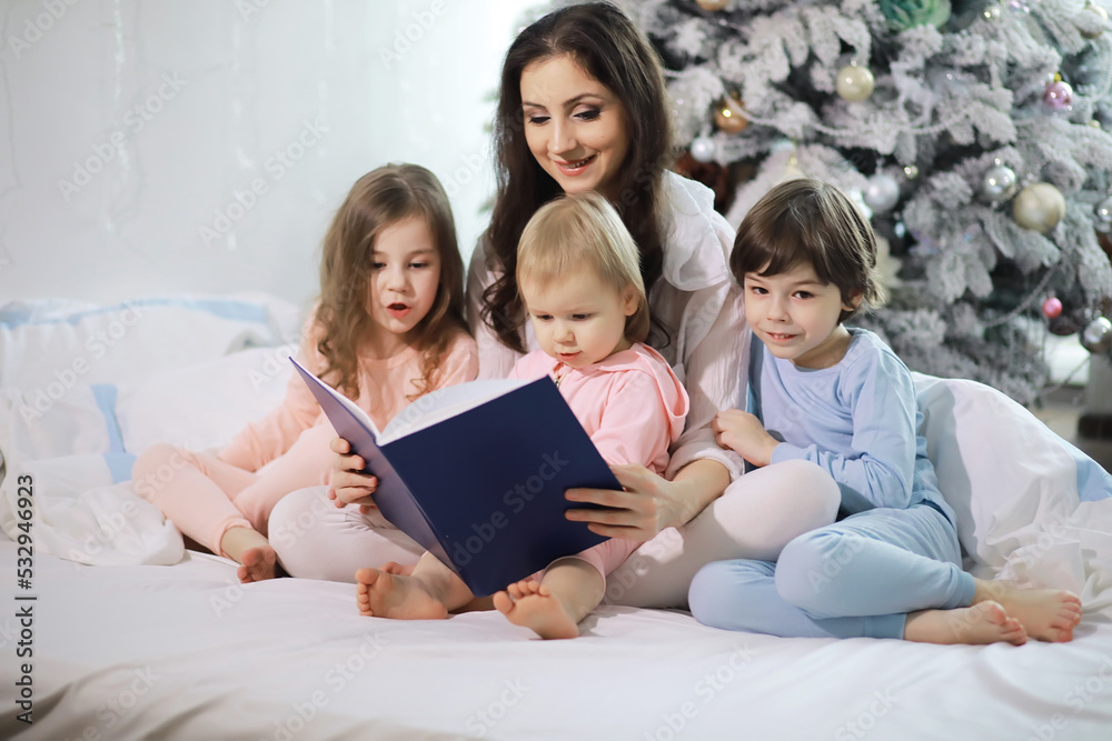 A family with children having fun on the bed under the covers during the Christmas holidays. A family with children having fun on the bed under the covers during the Christmas holidays.