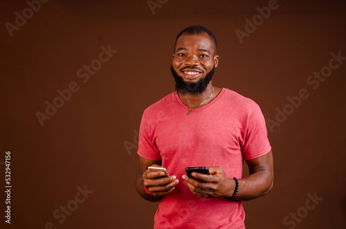excited african man using two cellphone to send message