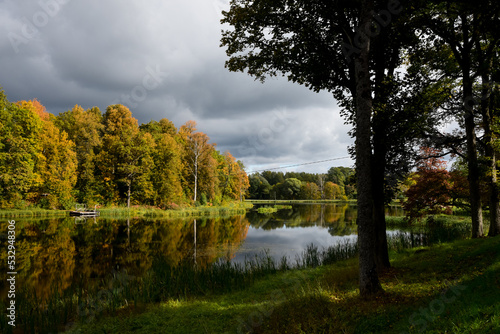 a beautiful view of the lake in autumn with the reflection of yellow-green trees and slow water in the absence of wind