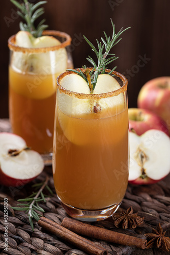 Apple cider cocktail with sliced apples and rosemary