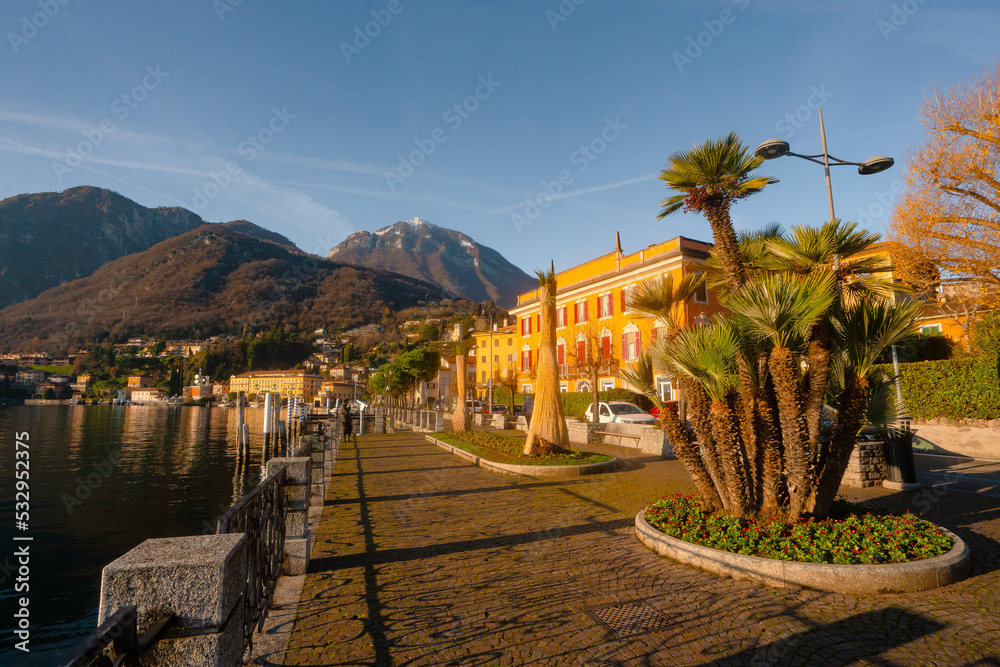 Menaggio , beautiful town on the shore of Lake Como , Lombardy . during autumn , winter sunny day : Lake Como , Italy : December 7 , 2019 Menaggio , beautiful town on the shore of Lake Como , Lombardy . during autumn , winter sunny day : Lake Como , Italy : December 7 , 2019