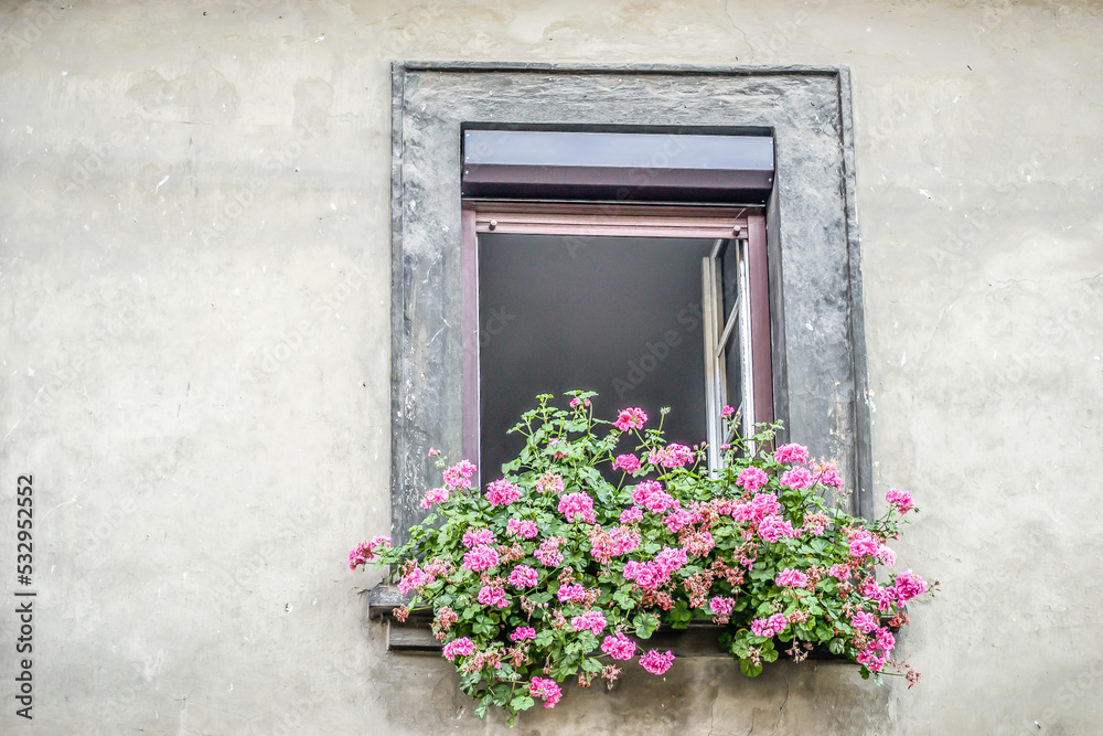 A window decorated with pink flowers.