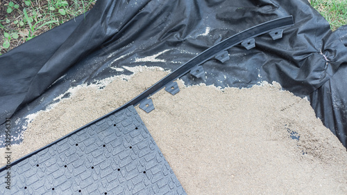Εκτύπωση καμβά Plastic landscape edging with polypropylene paver base panel, leveling sand and