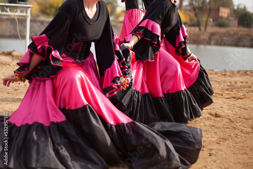 Gypsy dances in bright dresses. Girls dance on street Spanish dance. Bright fabric.
