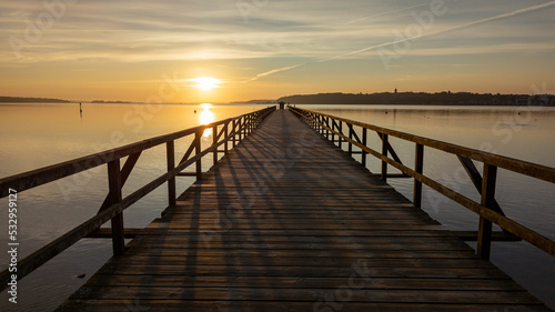 Wooden walkway in the foreground. Middle ground the Baltic Sea. Clear sky at sunset. Harrislee  Flensburg  Fjord  Germany
