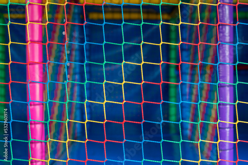 Protective net with square mesh connections used in kindergartens for safe games. Kids playground with safety equipment