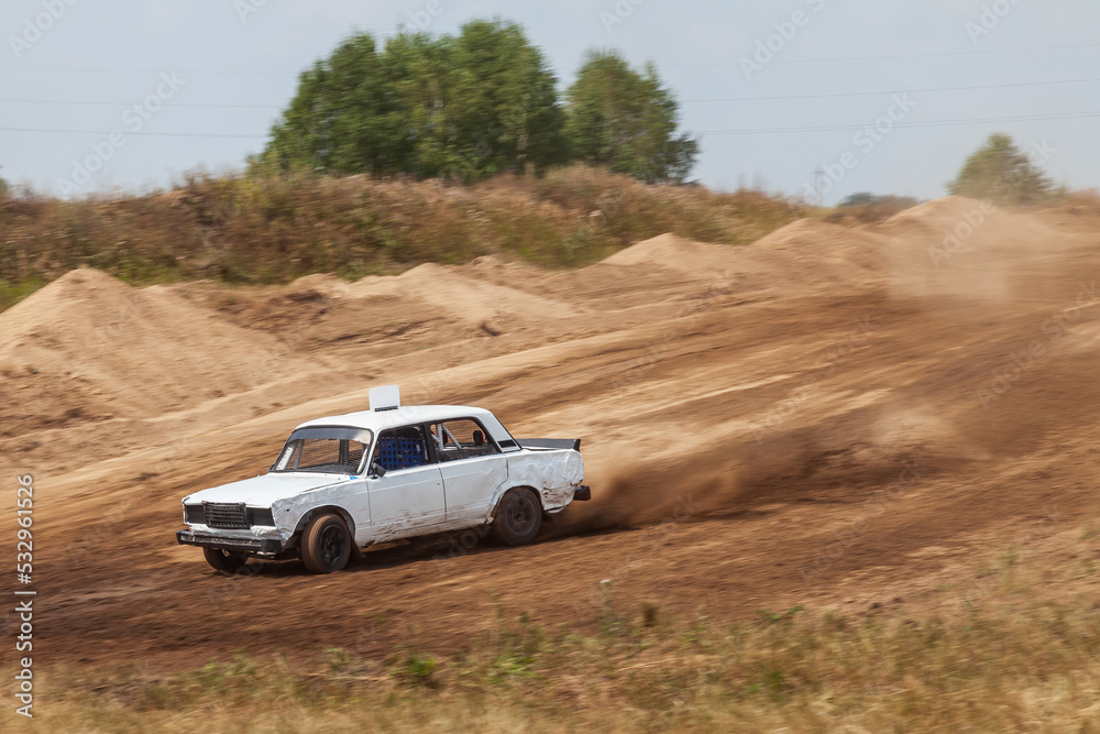 Rally off-road car make a turn with the clouds and splashes of sand, gravel and dust during rally championship