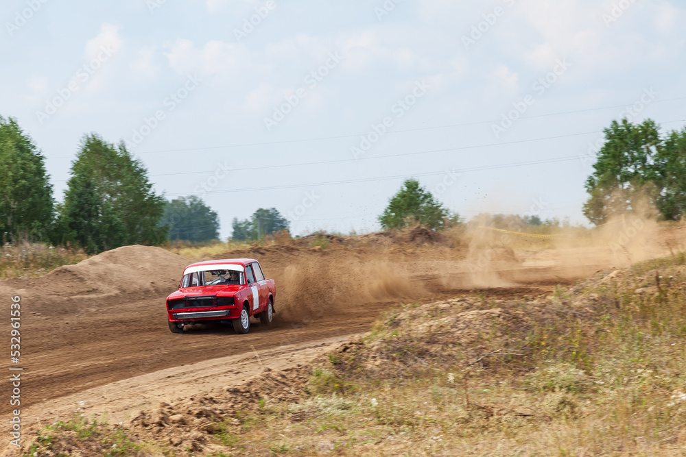Rally off-road car make a turn with the clouds and splashes of sand, gravel and dust during rally championship