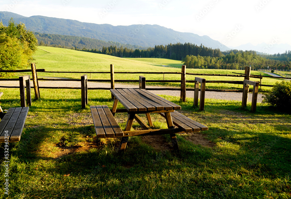 a sunlit summery beer garden with the lush alpine meadows and the Bavarian Alps in the background, Steingaden, Bavaria, Germany a sunlit summery beer garden with the lush alpine meadows and the Bavarian Alps in the background, Steingaden, Bavaria, Germany