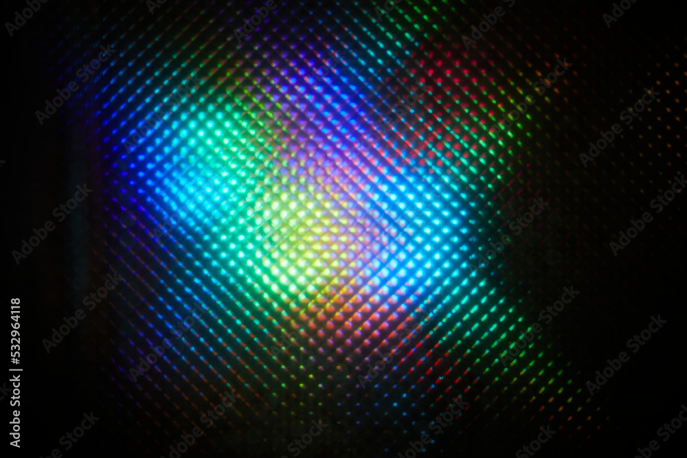 Blurred abstract colorful pattern. Light glares with a spectral gradient on a dark background.