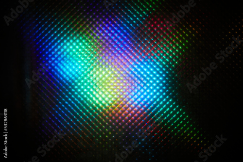 Blurred abstract colorful pattern. Light glares with a spectral gradient on a dark background.