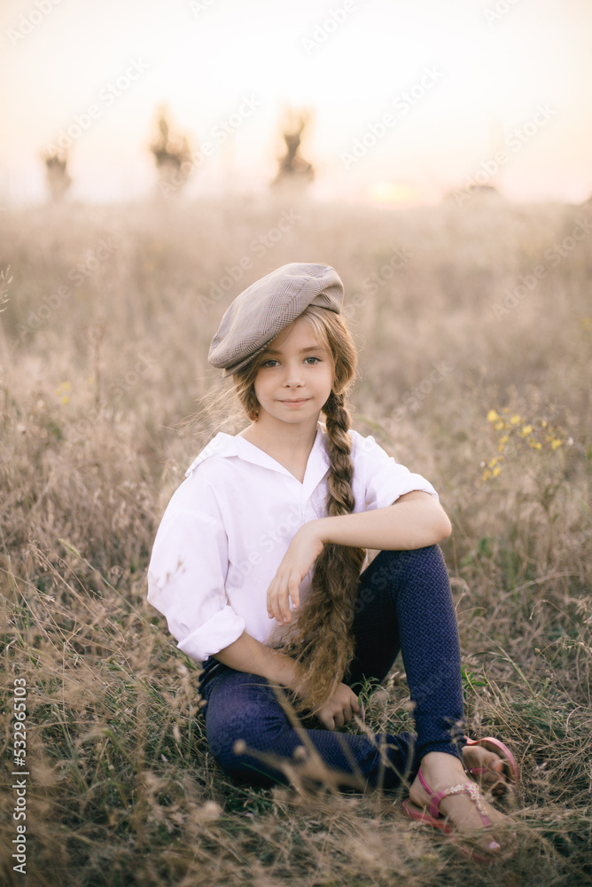 cute little girl with a long braid of blond hair in a white shirt and a men's vintage cap at sunset in a summer field.
cute little girl with a long braid of blond hair in a white shirt and a men's vintage cap at sunset in a summer field.