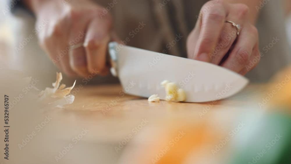 Cooking, garlic and hands of woman with knife prepare food or vegetables for dinner, brunch or breakfast salad. Cut, nutritionist and hand of girl chef in kitchen making health diet lunch Cooking, garlic and hands of woman with knife prepare food or vegetables for dinner, brunch or breakfast salad. Cut, nutritionist and hand of girl chef in kitchen making health diet lunch