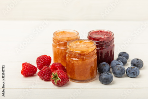 Honey in a glass jar. Raspberry and blueberry honey jam. Remedy for colds and respiratory diseases. Organic product of a vegetarian diet. copy space. copy space