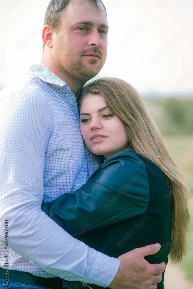 A couple of a tall young man and his girlfriend with long blond hair are walking in the city in nature. Emotions and feelings. Life style A couple of a tall young man and his girlfriend with long blond hair are walking in the city in nature. Emotions and feelings. Life style