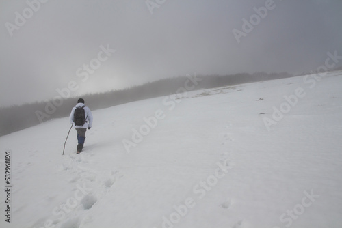 Hiker on the summit of a mountain with snow