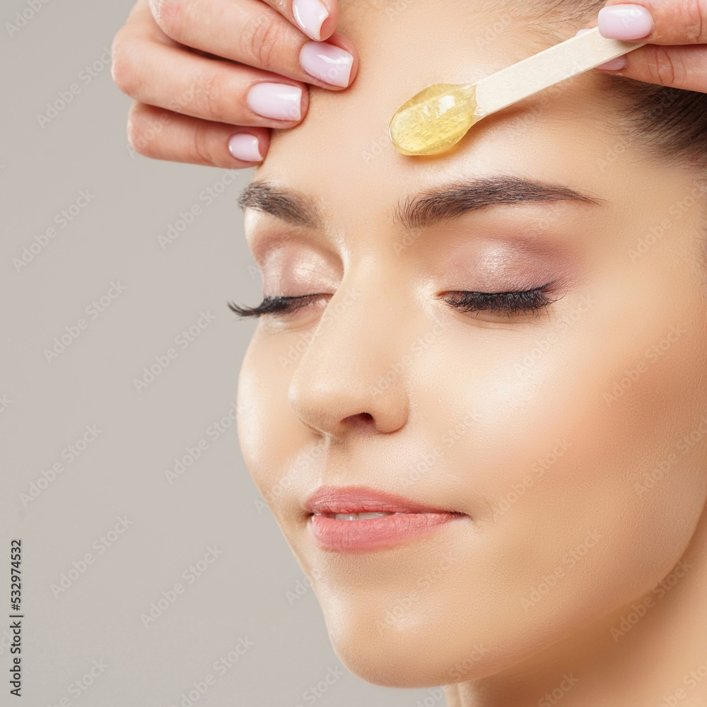 Hair removal, beauty and health concept. A young girl is getting an epilation procedure. A processional beauty worker is making depilation with hot wax. Hair removal, beauty and health concept. A young girl is getting an epilation procedure. A processional beauty worker is making depilation with hot wax.