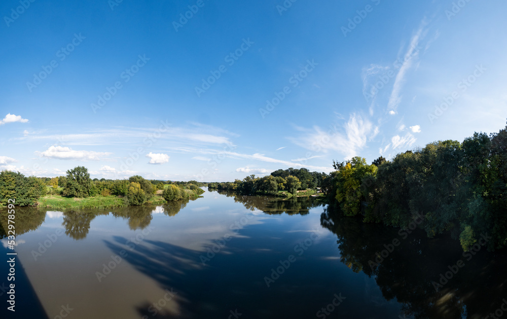Panorama błękitnej rzeki Odry na terenach podmiejskich o letniej porze w zachodniej Polsce - obrazy, fototapety, plakaty 