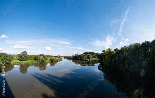 Panorama błękitnej rzeki Odry na terenach podmiejskich o letniej porze w zachodniej Polsce