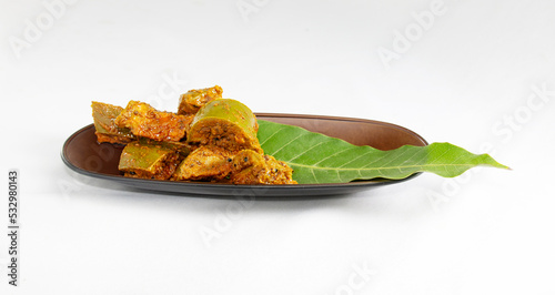 cennai mango pickle and leaf on a brown tray.