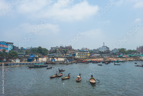 Beautiful landscape of Sadarghat river port on Buriganga river in Dhaka. Ferry boats on the river with a cloudy sky background.