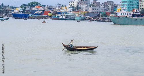 Beautiful landscape of Sadarghat river port on Buriganga river in Dhaka. Ferry boats on the river with a cloudy sky background. photo