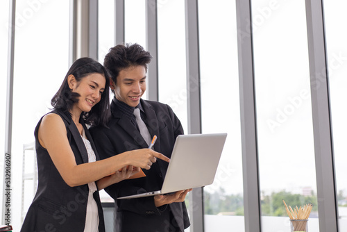Businessman and businesswoman meeting, discussing and working together with laptop.