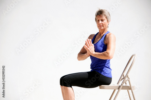 Middle aged senior yoga woman demonstrating asana for aging bodies. 