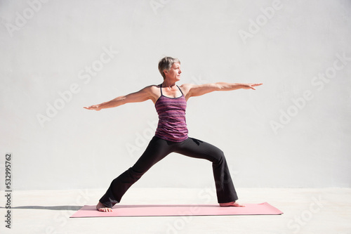 Fototapeta Naklejka Na Ścianę i Meble -  Middle aged senior yoga woman demonstrating asana for aging bodies. 