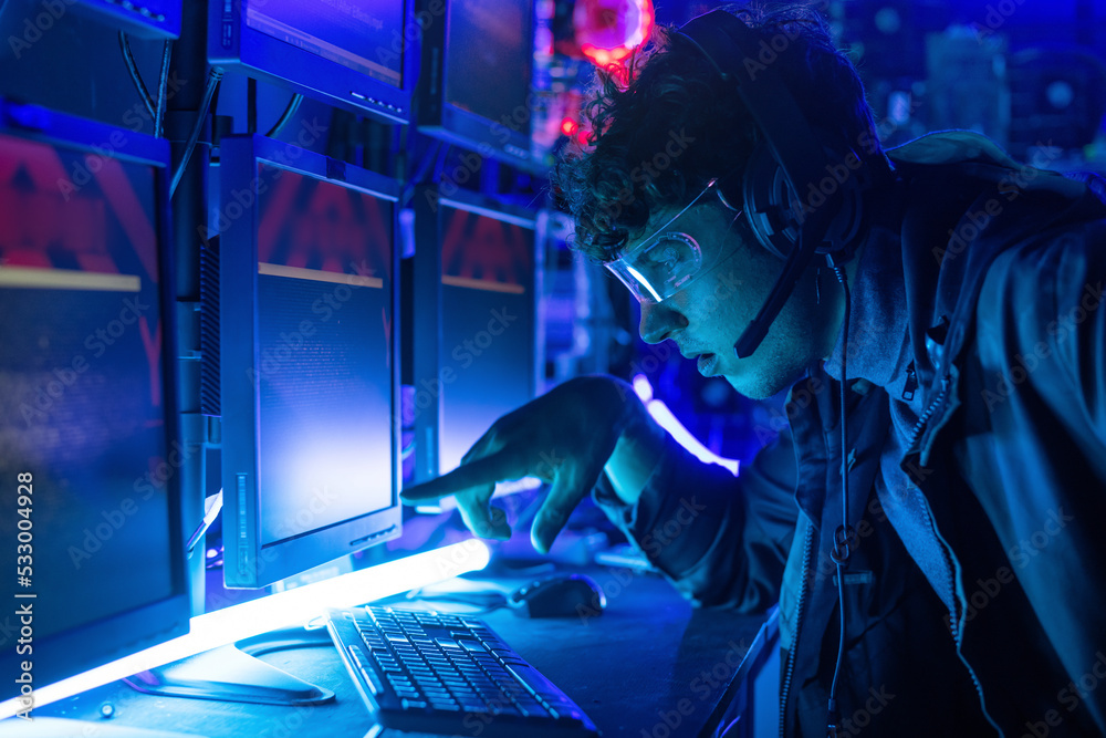 Caucasian young man in headset controlling playing game at home, colorful lights room, fun and exciting hobby concept Caucasian young man in headset controlling playing game at home, colorful lights room, fun and exciting hobby concept