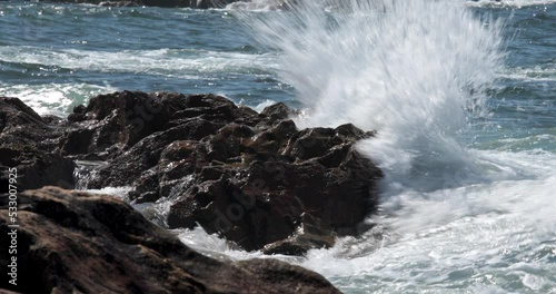 The wave crashes on the rocks: energy and natural beauty