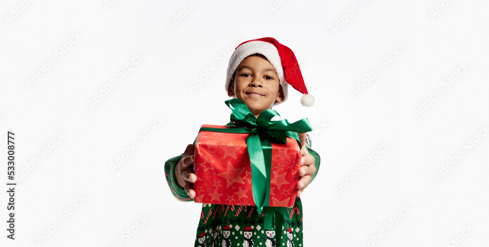 Gift for you. Happy smiling child in a knitted colorful sweater holds box in festive package. Boy rejoices at holiday, Christmas, New Year. Gift for you. Happy smiling child in a knitted colorful sweater holds box in festive package. Boy rejoices at holiday, Christmas, New Year.