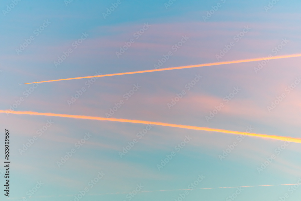 Airliners in flight in a cloudy pink and orange sky in late summer. Airliners in flight in a cloudy pink and orange sky in late summer.