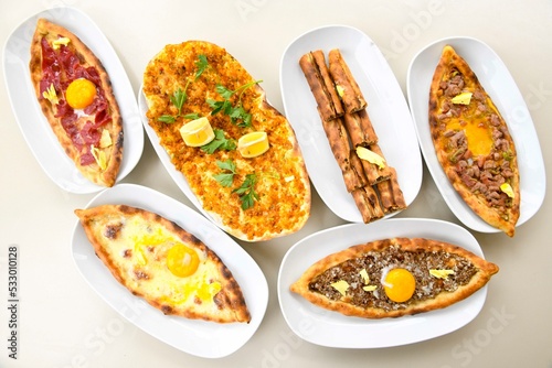 Traditional Turkish cuisine. Pizza, pita, pidesi, sucuk, hummus, kebab. Many dishes on the table. Serving dishes in restaurant. Background image. Top view, flat lay
