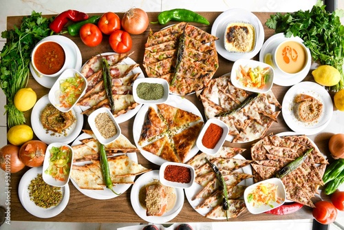 Delicious meat kebab with fresh vegetable salad served with variety of Turkish dishes and appetizers. Top view of assorted Turkish food and meze, tasty and healthy Mediterranean cuisine.