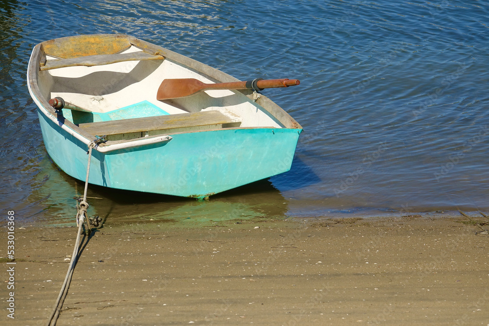 Naklejka premium classic wood rowboat floating on the bay
