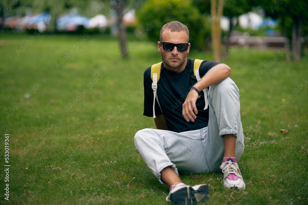 Young handsome bearded man in stylish black clothes looking through sunglasses, with a fashionable hairstyle, with backpack relaxing on the street. A handsome modern guy. Street style.
Young handsome bearded man in stylish black clothes looking through sunglasses, with a fashionable hairstyle, with backpack relaxing on the street. A handsome modern guy. Street style.