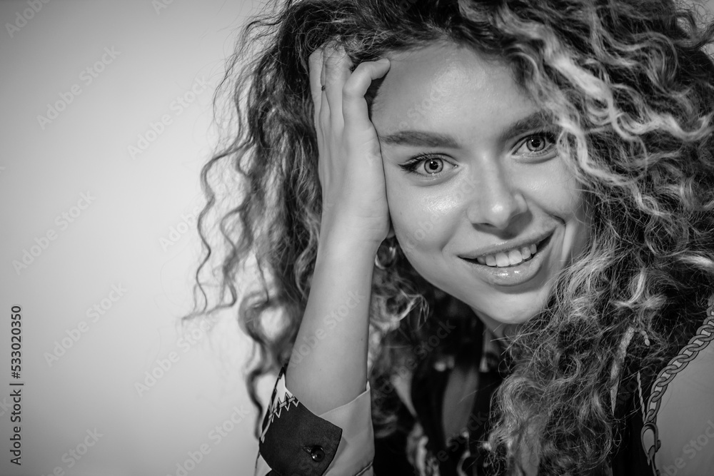Portrait of Beautiful Young Woman with Curly Hair. Cute Girl Looking At Camera And Smiling Portrait of Beautiful Young Woman with Curly Hair. Cute Girl Looking At Camera And Smiling