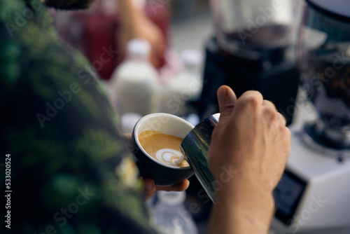 men's hands pouring milk and preparing fresh cappuccino, coffee pot and cooking concept, morning coffee