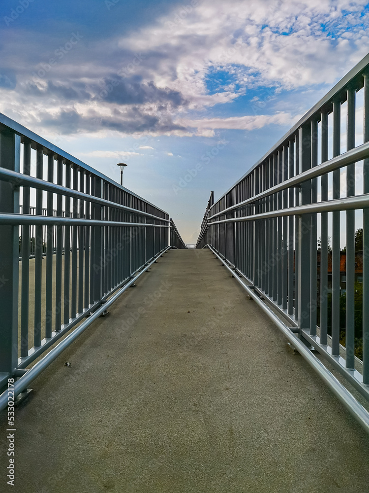 Long high concrete footbridge over city highway