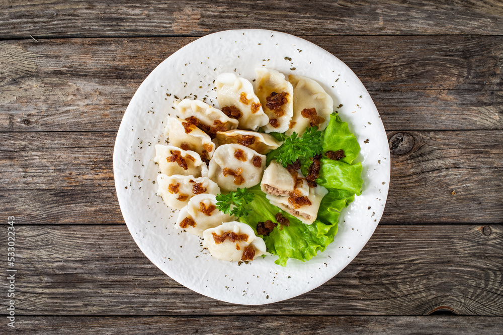 Dumplings - meat dumplings with onion and bacon on wooden table
Dumplings - meat dumplings with onion and bacon on wooden table