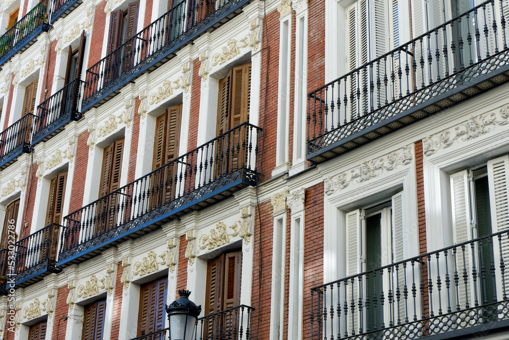 Classical vintage balconies decorated with stucco moldings on the buildings downtown Madrid, Spain