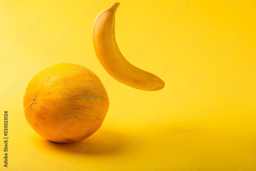 Round melon and banana on a yellow background. Round melon and banana on a yellow background.